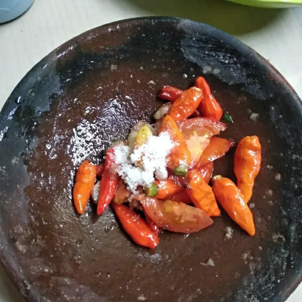 Siapkan cobek, masukkan bahan sambal yang sudah digoreng, tambahkan garam dan gula pasir, haluskan.