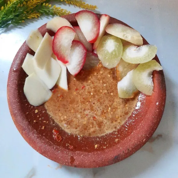 Tata buah dalam dalam bersama dengan bumbu. Rujak madu siap disajikan.