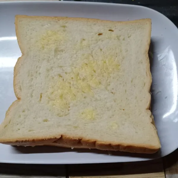 Tutup dengan roti yang satunya. Kemudian oles permukaan roti dengan margarin.
