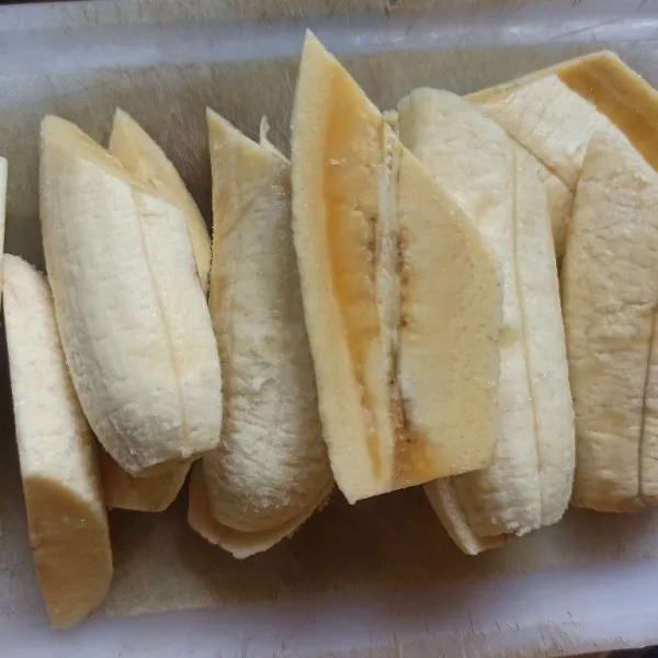 Kupas pisang dan potong menjadi 2 bagian kemudian belah kembali menjadi 2 bagian.