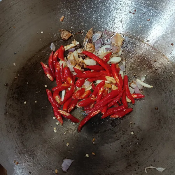 Tumis bawang sampai harum lalu masukkan cabai merah. Aduk merata dan tumis hingga agak kering.