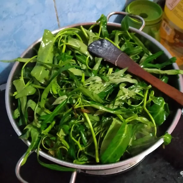 Masukkan kangkung yang sudah dipetiki daun dan batangnya, aduk rata sampai kangkung kempis.