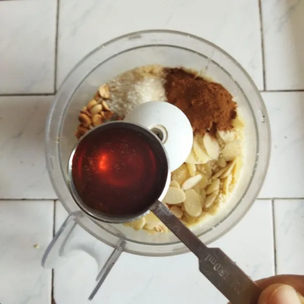Siapkan food processor, lalu masukkan almond, kacang tanah, apricot, garam, gula halus, cengkeh, dan kayu manis, lalu haluskan. Setelah halus letakkan kacang di dalam mangkuk