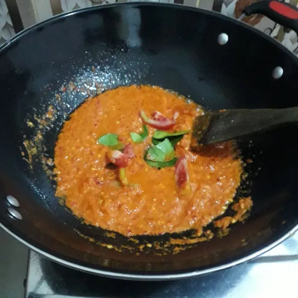 Siapkan wajan, panaskan 3 sdm minyak goreng lalu tuang bumbu yang telah dihaluskan ke dalam wajan. Tumis sampai harum lalu tambahkan tomat dan daun jeruk.