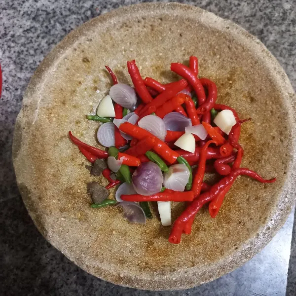 Tuang bahan sambal pada cobek, tambahkan terasi bakar.