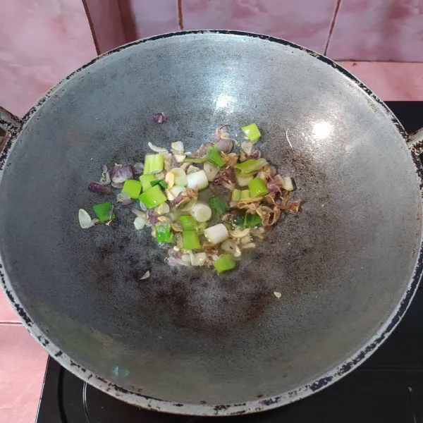 Tumis bawang merah dan bawang putih sampai wangi, lalu masukkan irisan daun bawang prei.