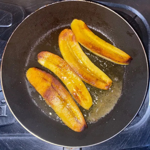 Kupas pisang lalu belah menjadi dua bagian lalu panaskan margarin sampai meleleh. Panggang pisang sampai kedua sisinya berwarna kecokelatan lalu angkat.