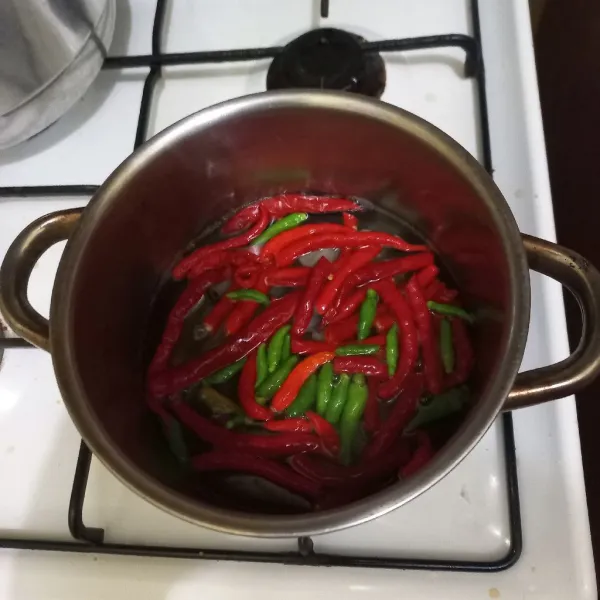 Didihkan air pada panci secukupnya, masukkan cabe rawit, cabe merah keriting, bawang putih dan bawang merah hingga layu, tiriskan.