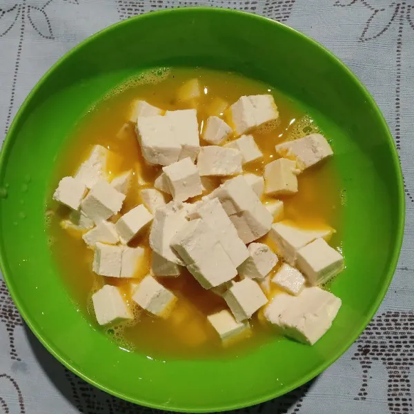 Kocok lepas telur dengan garam, kaldu jamur. Masukkan tahu dan kentang, aduk rata.