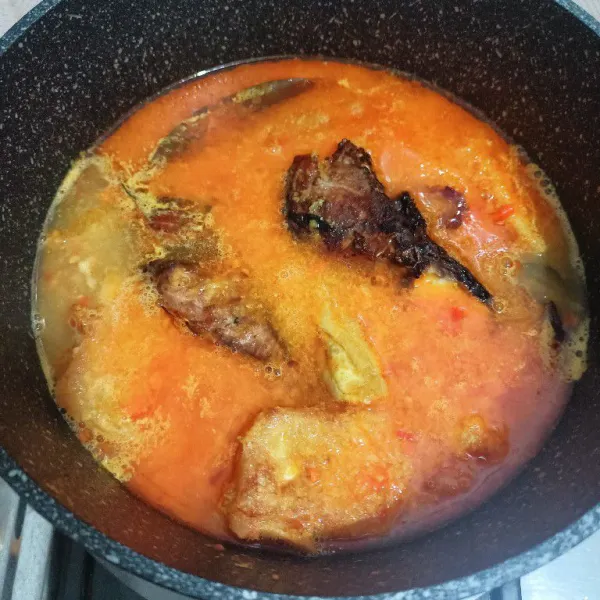 Tambahkan air masak hingga mendidih, masukkan tahu dan manyung yang telah digoreng.