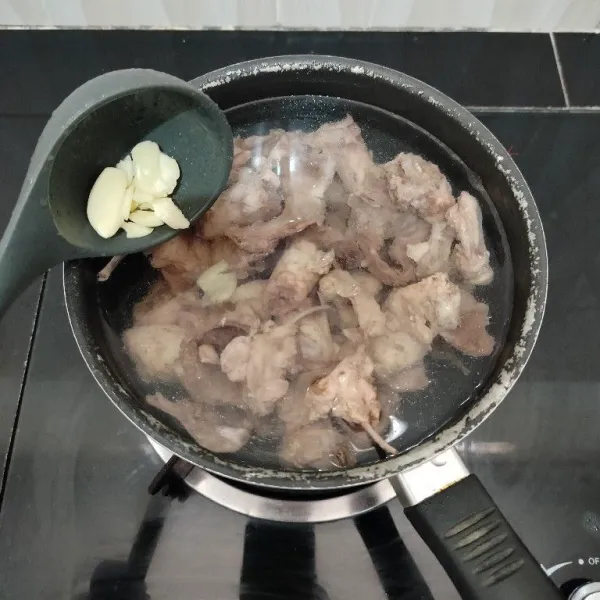 Setelah itu rebus kembali tulang ayam dengan air yang baru, tambahkan bawang putih. Masak hingga daging yang masih menempel di tulang menjadi empuk.