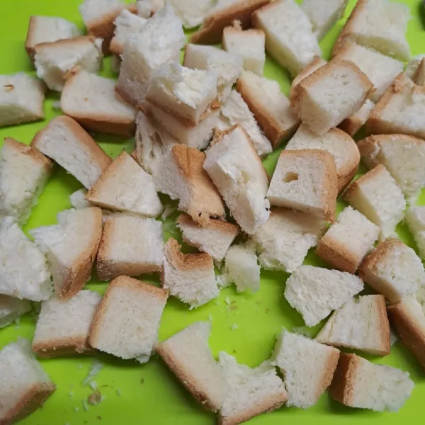 Potong dadu pinggiran roti tawar.