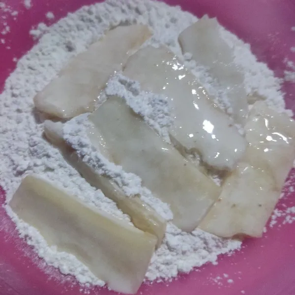 Gulingkan singkong yang telah dicelup tadi ke dalam campuran tepung, aduk sambil di cubit-cubit agar keriting.