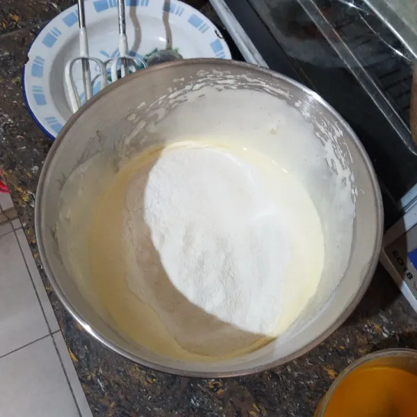 Masukkan terigu, tuang air soda, tambahkan vanili cair dan emulsifier, mixer asal rata.