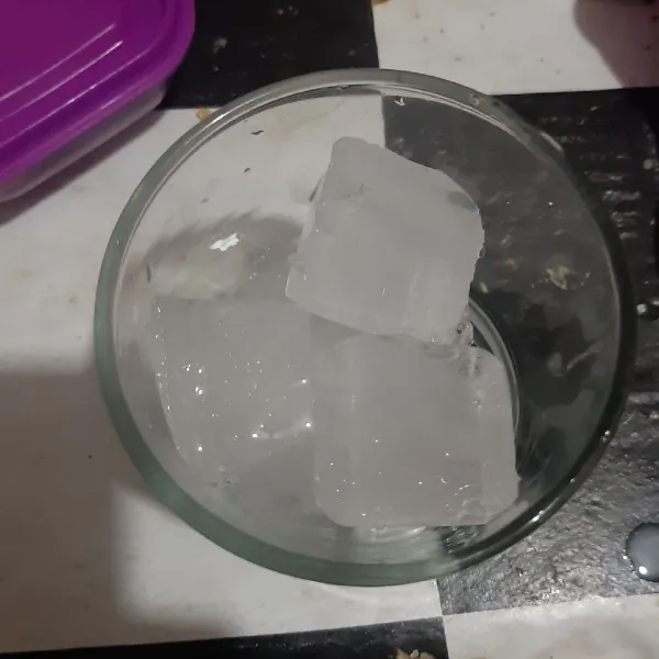 Letakkan es batu ke gelas.