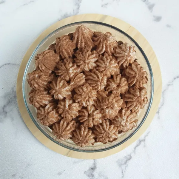 Taburi cokelat bubuk diatas whipped cream, simpan dalam kulkas hingga dingin, dan Banoffee Dessert Bowl siap disajikan.