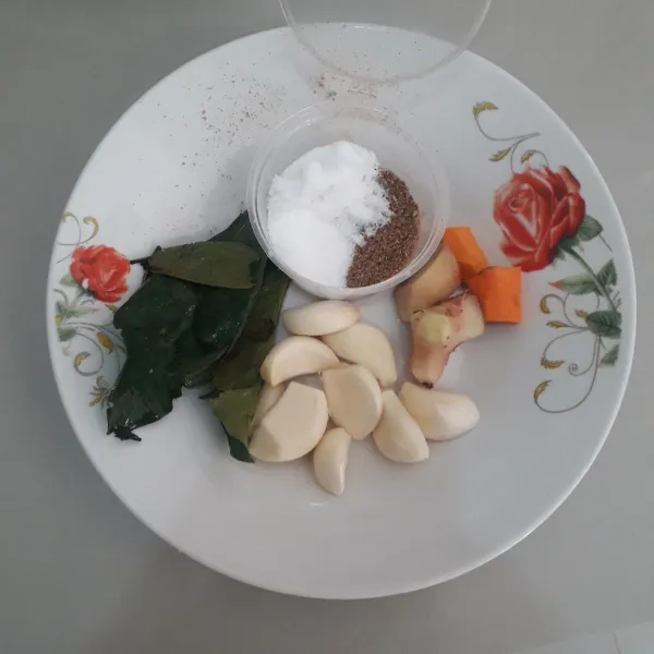 Siapkan bumbu ungkep ayam. Kupas bawang putih. Cuci bersih dan kupas jahe kunyit lengkuas.