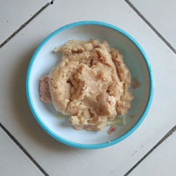Haluskan daging ayam dan bawang putih setelah itu pindahkan ke wadah lain.