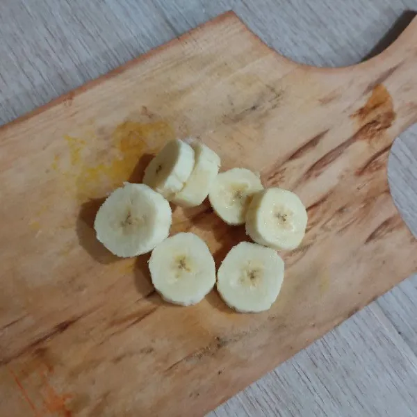 Potong pisang menjadi bulat tipis seperti koin.