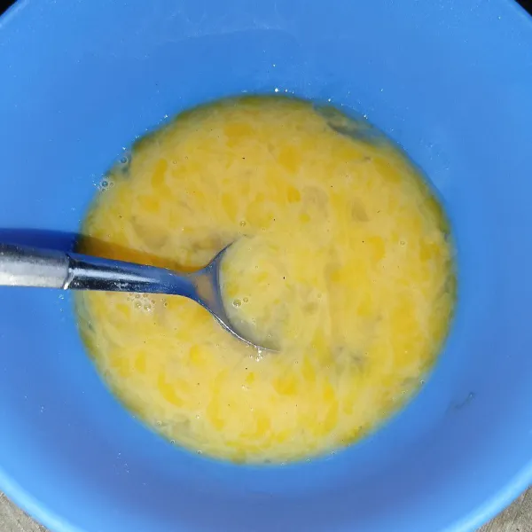 Pecahkan telur dan tambahkan garam, lada bubuk dan kaldu jamur, lalu kocok lepas.