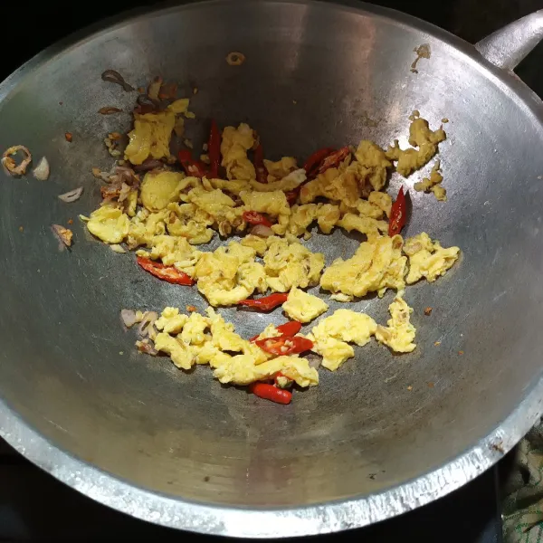 Tumis bawang putih dan cabe sampai harum, sisihkan pada tepi wajan lalu masukkan telur, aduk orak-arik. Kemudian aduk merata.