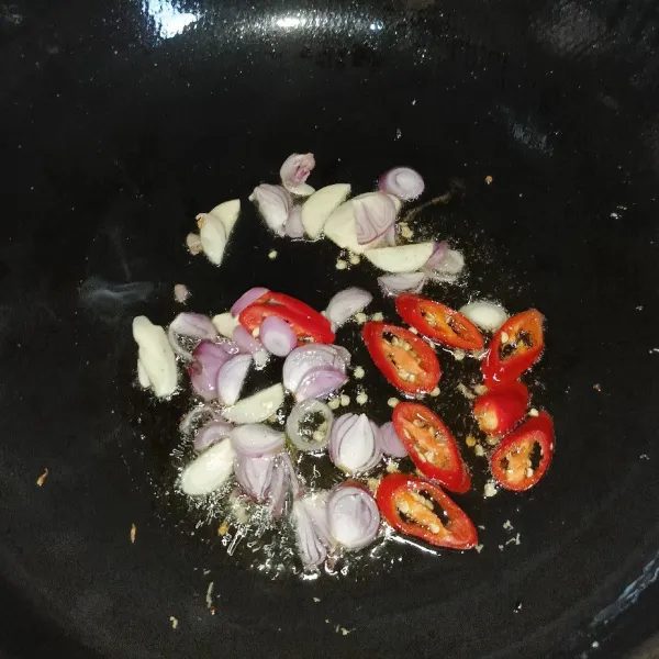 Iris tipis bawang merah, bawang putih, dan cabai merah, lalu tumis hingga harum