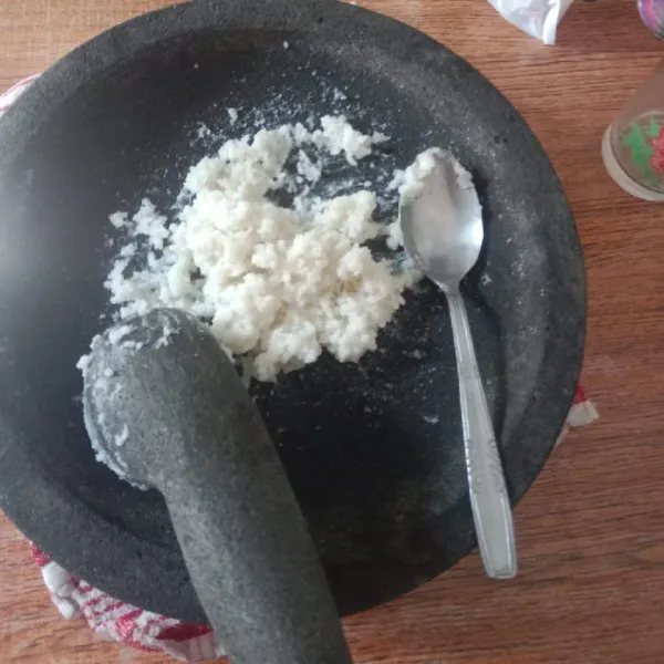 Tumbuk halus nasi kemudian pindahkan ke dalam wadah.