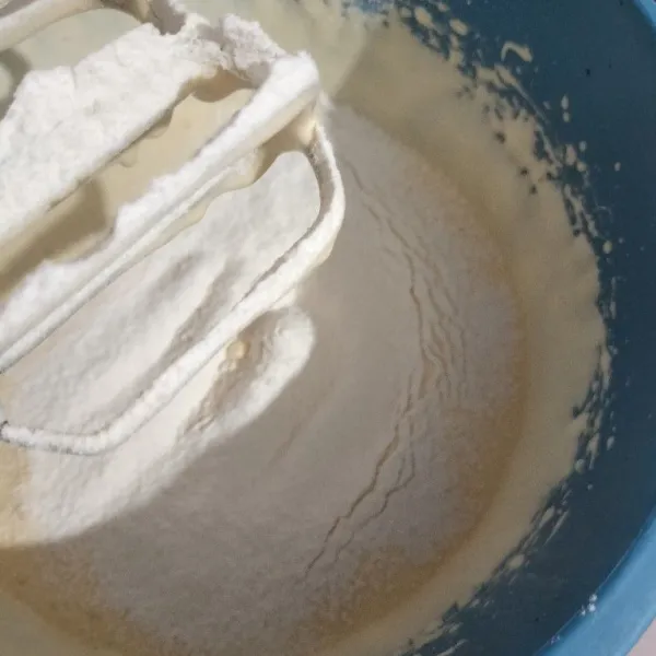 Masukkan tepung terigu, tepung maizena, dan susu bubuk yang sudah diayak secara bertahap.
Mixer sebentar asal rata dengan kecepatan rendah.