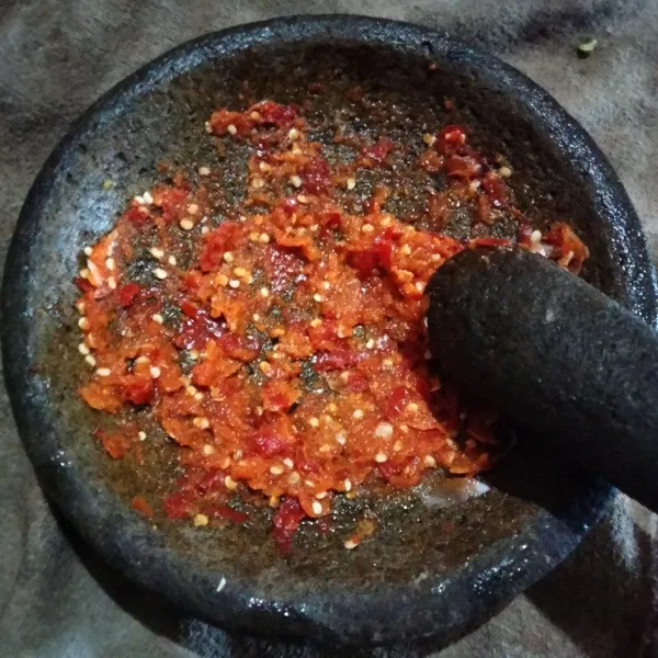 Haluskan bawang merah, bawang putih, cabai rawit dan cabai merah keriting.
