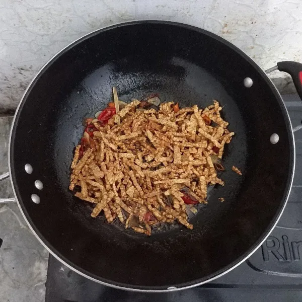 Masukkan tempe yang sudah digoreng kering, aduk hingga tercampur merata, kemudian angkat dan sajikan.