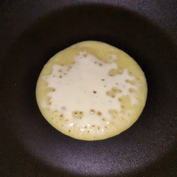 Panaskan teflon, lalu tuang satu sendok sayur adonan pancake. Tunggu hingag semua lubang merata, kemudian balik sebentar lalu angkat