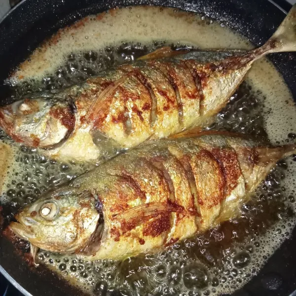 Panaskan minyak lalu masukkan ikan, goreng hingga kuning keemasan. Angkat dan tiriskan.