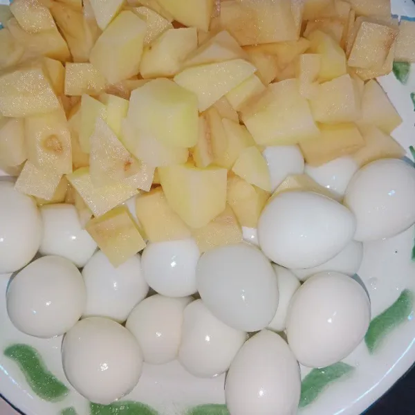 Potong kentang dadu dan kupas cangkang telur puyuh.