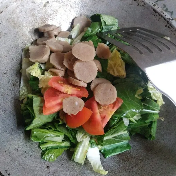 Masukkan potongan bakso dan tomat.