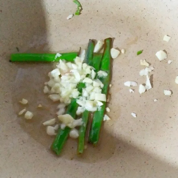 Panaskan minyak. Tumis bawang putih dan daun bawang.