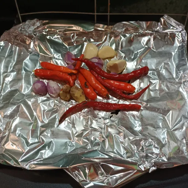 Lalu bakar bawang merah, bawang putih, cabe merah keriting, cabe rawit dan kencur. Bakar sampai tidak berbau langu.