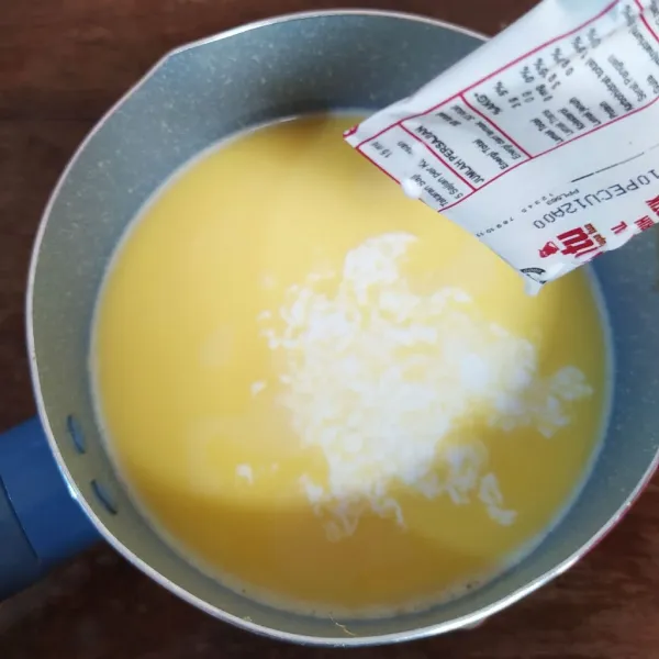 Tuang susu kental manis dan santan instan, lalu aduk rata.