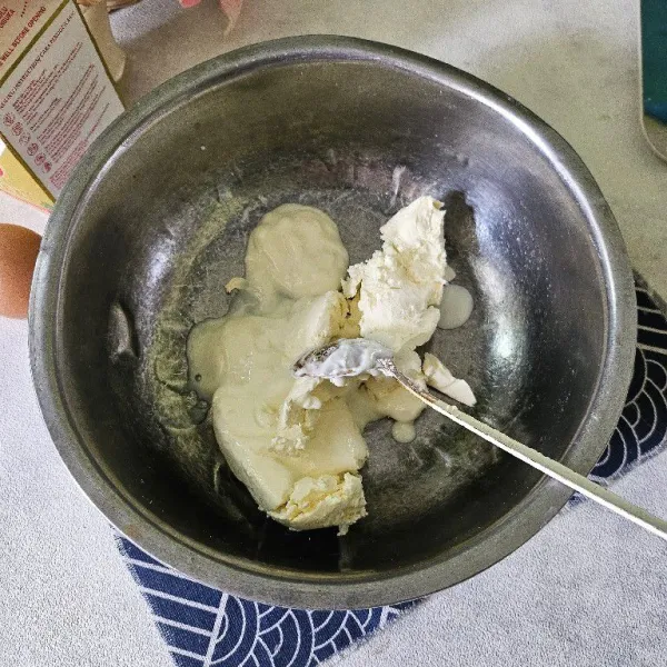 Campurkan cream cheese dengan sour cream kemudian aduk hingga lembut.