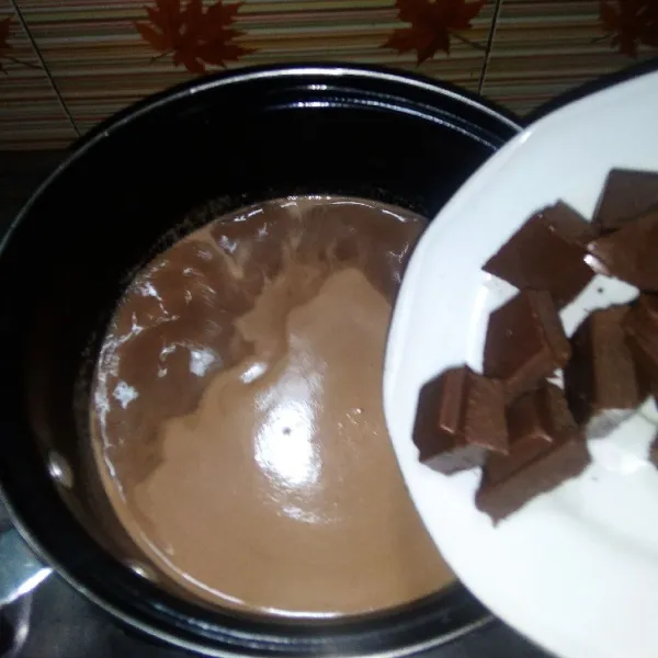 Siapkan panci. Masak agar-agar, gula, cokelat bubuk, dan susu cair hingga mendidih. Kemudian masukkan cokelat batang. Masak hingga kembali mendidih dan coklat meleleh sempurna. Matikan api.