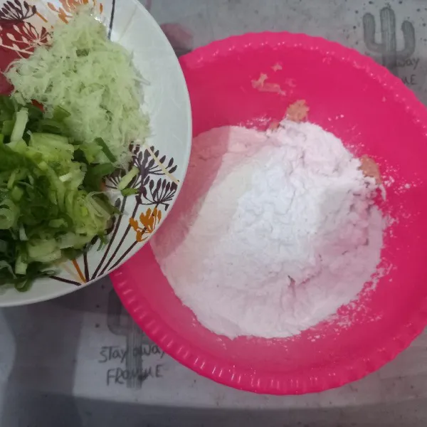 Masukkan tepung tapioka, tepung terigu, penyedap rasa, daun bawang dan labu siam yang telah diparut.