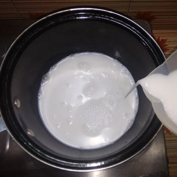 Siapkan panci, masukkan agar-agar, gula, dan susu cair, lalu aduk rata. Tambahkan vanilla ekstrak, kemudian masak hingga mendidih. Matikan api sambil terus di aduk hingga uap berkurang.