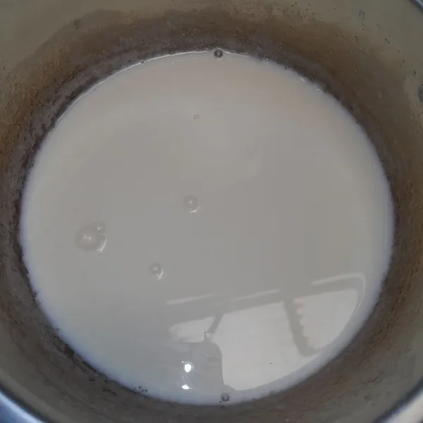 Masak bubuk agar-agar, susu UHT, susu kental manis, gula pasir, dan air (bahan lapisan putih) sampai mendidih.