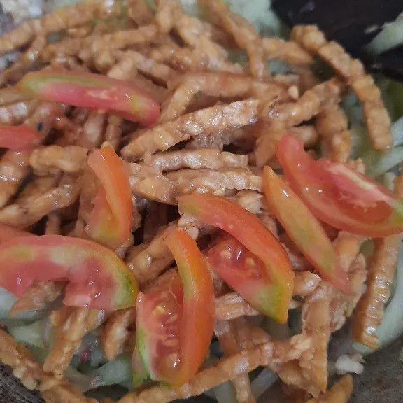Masukkan juga tempe dan tomat, aduk rata.