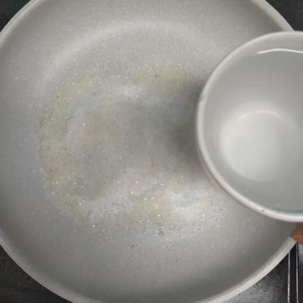 Untuk membuat puding cocopandan, campur bubuk jelly dengan garam dan gula pasir.
