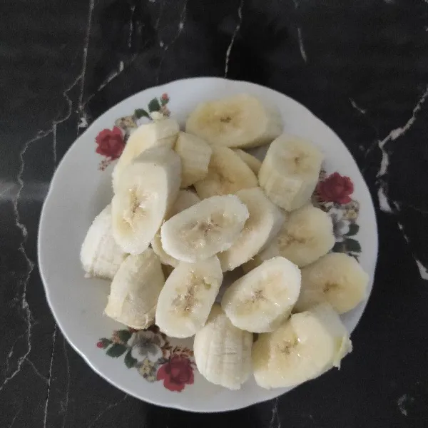 Kupas pisang lalu potong sesuai selera.