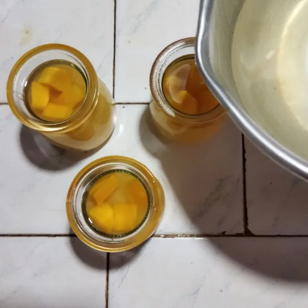 Kemudian tata potongan mangga dadu di atasnya puding mangga, tuang jelly bening di atasnya. Biarkan beku, lalu masukkan ke dalam kulkas. Puding susu mangga siap disajikan dingin.