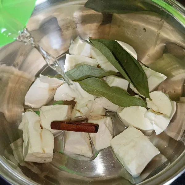 Masukkan singkong, kayu manis dan daun salam ke dalam panci. Kemudian tuang air secukupnya dan nyalakan kompor.