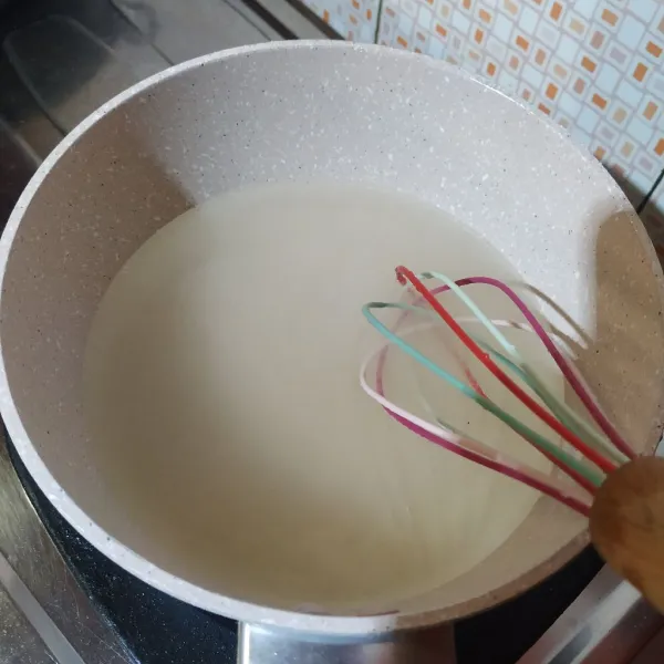 Masak bubuk jelly rasa leci, gula pasir, dan air sambil diaduk hingga mendidih.