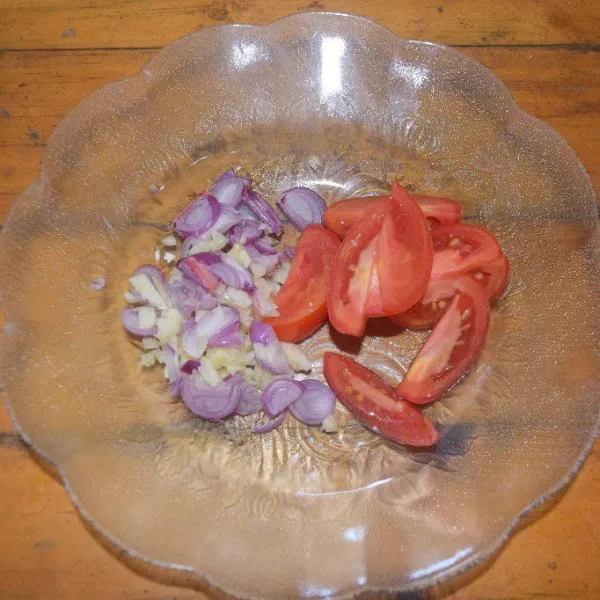 Cincang bawang putih dan bawang merah serta potong juga tomat.