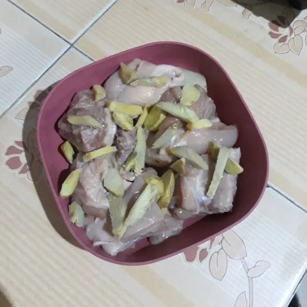 Pindahkan ayam ke dalam wadah tahan panas lalu tata irisan jahe di atasnya.